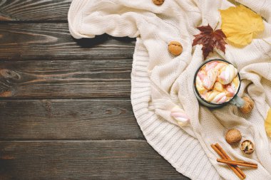 Sonbahar çerçeve marshmellows, fındık, tarçın, ekose, elma ile kakao bir fincan kurutulmuş sonbahar yaprakları, yaptı. Kahverengi ahşap zemin üzerinde Üstten Görünüm