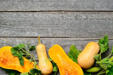 Pampkin ve kabak yeşil yaprakları vintage tahta masada. Sonbaharda hasat arka plan