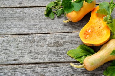 Pampkin ve kabak yeşil yaprakları vintage tahta masada. Sonbaharda hasat arka plan