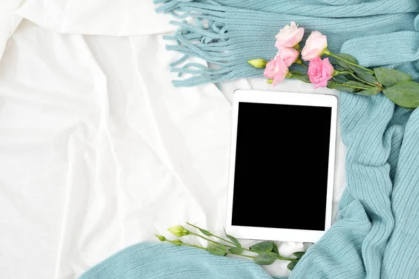 Düz yatıyordu tablet, telefon, fincan kahve ve beyaz battaniye ile turkuaz ekose çiçekler
