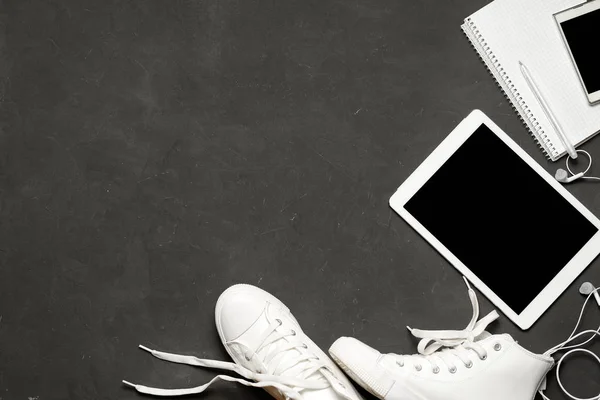 Flat lay Of White Sneakers En fondo negro con teléfono, auriculares, tableta, libro de copias —  Fotos de Stock