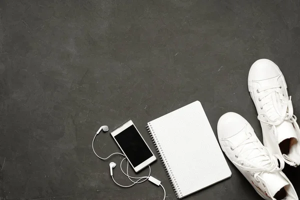 Flat lay Of White Sneakers En fondo negro con teléfono, auriculares, tableta, libro de copias —  Fotos de Stock