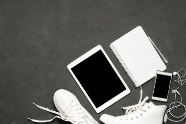 Şık rahat düz, beyaz spor ayakkabı siyah arka plan yattı telefonu, kulaklık, tablet, kopya kitap