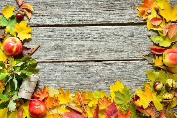 Cadre plat de feuilles rouges, vertes et jaunes d'automne, glands et pommes sur fond bois vintage . — Photo