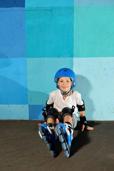 Sevimli küçük atletik çocuk mavi grafiti duvara oturan silindir üzerinde — Stok fotoğraf