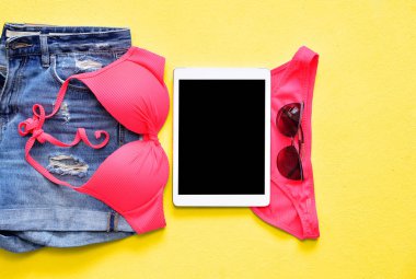 Kadın yaz bikini mayo ve tablet ve güneş gözlüğü ile mavi aksesuarlar.