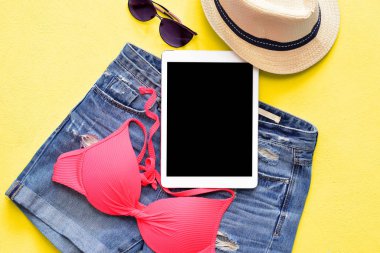 Kadın yaz bikini mayo ve tablet ve güneş gözlüğü ile mavi aksesuarlar.