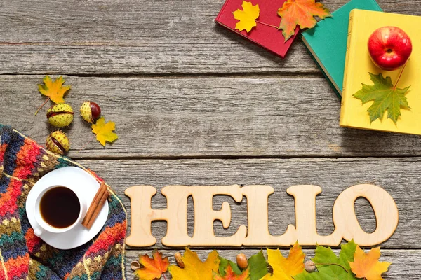 Frame of autumn red, green and yellow leaves, apples with cup of coffee or tea, big word hello books on vintage background. — Stock Photo, Image