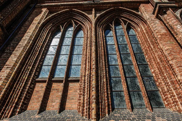 Architektonische Details der Kirchen St. Annes und Bernadines in Vilnius. große Fenster und rote Ziegel Stockfoto