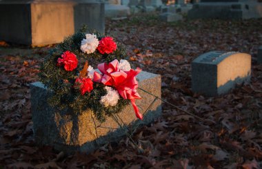 Gün batımında mezar taşındaki çiçekler