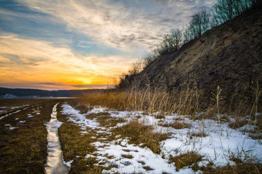 Günbatımı üzerinde bir kış hillside ve çayır