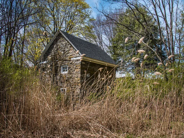 Malý kamenný dům v travnaté louce — Stock fotografie
