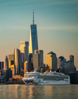 A Norwegian cruise ship passes silently beneath the gaze of the Freedom Tower at One World Trade Center clipart