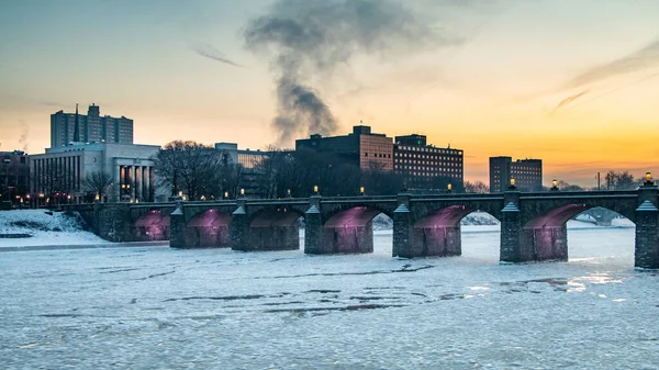 冬日的日出时分 在美国宾夕法尼亚州哈里斯堡市的市场桥下面 冰块沿着苏奎哈纳河流过 图库图片