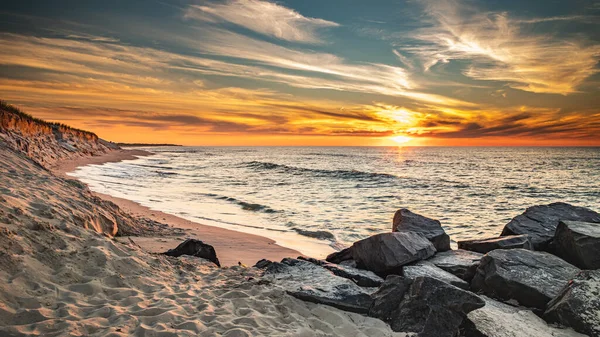 在大西洋上空多姿多彩的海滩日出中 沙丘和花岗岩巨石引人注目 免版税图库照片