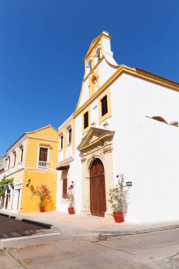 Cartagena duvarlı şehir, Kolombiya bir sokakta sömürge kilise mimarisi. Renkli binalar açık mavi gökyüzü karşı boyalı.