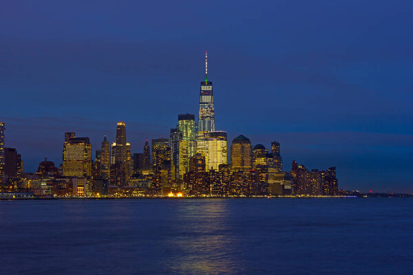 Low Manhattan skyline at night with reflection in Hudson River. New York urban panorama on a clear night in winter.