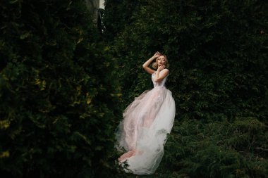 parkta erken ilkbaharda. Beyaz güzel yemyeşil elbiseli kız. sarışın akşam saç modeli ve etkileyici makyaj ile sarışın model