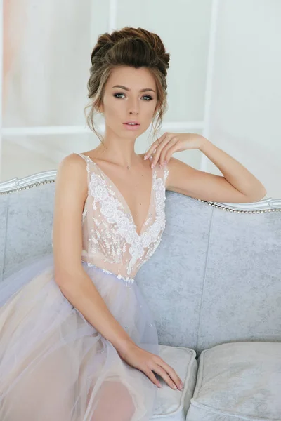 ベルベットのソファの上の若い美しいモデル ロマンチックなラベンダーのドレスを着た女性 — ストック写真