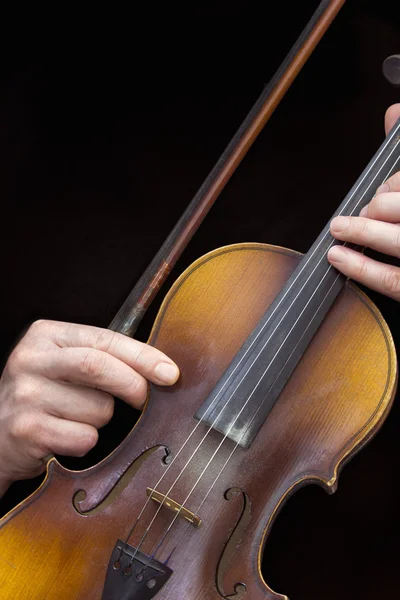 Mannen handen met oude viool in een zwarte achtergrond — Stockfoto