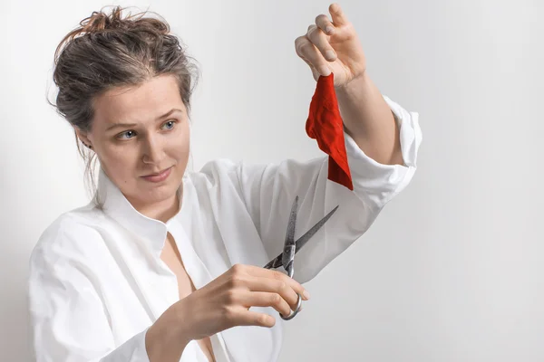 Woman  with old scissors and a small piece of red cloth — Stock Photo, Image