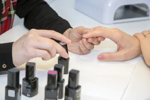 Manicure doen manicure client schilderij nagels met lak — Stockfoto