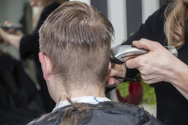 Парикмахер работает с волосами в парикмахерской — стоковое фото