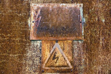 Yüksek gerilim uyarı işareti ile eski paslı teneke yüzey