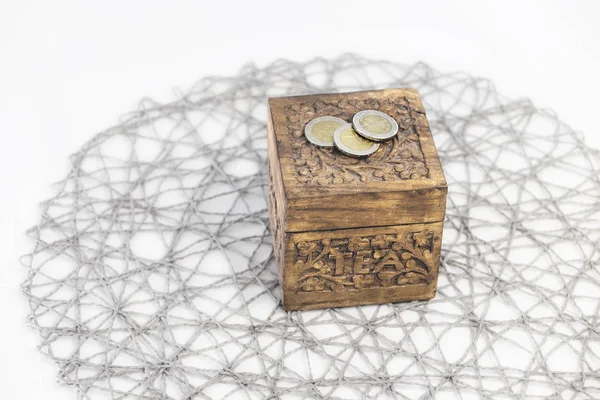 Theekistje met drie euro munten op een witte tafel — Stockfoto