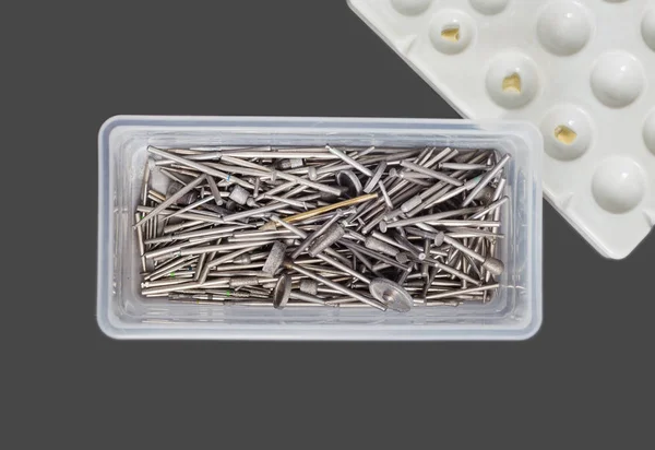 Cortadores dentales usados, taladros y rebabas en una caja de plástico . —  Fotos de Stock