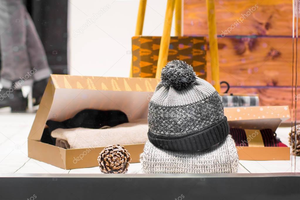 Knitted hat  with pompons in a store showcase