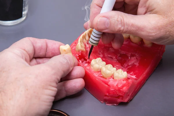 Mężczyzn rąk do pracy z elektrycznym waxer na czerwonym woskiem stomatologiczne tryb — Zdjęcie stockowe