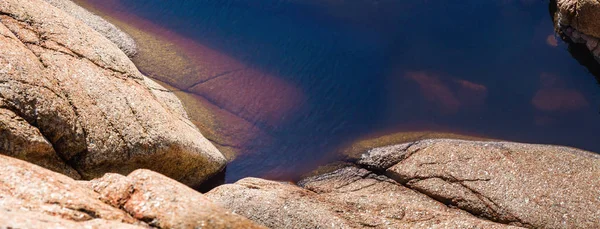 Фрагмент красной скалы с водой — стоковое фото