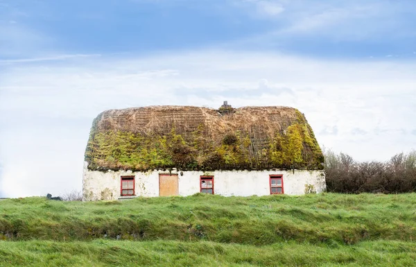 Old abandoned white house with a mossy roof — Stock Photo, Image