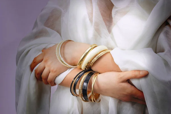 Frauenhände mit goldenen Armbändern — Stockfoto