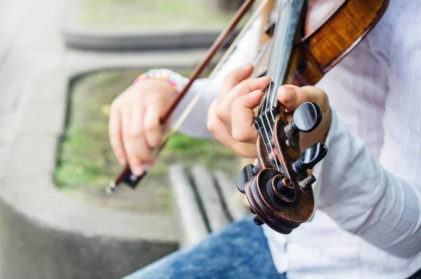 Руки девушки на скрипичных струнах — стоковое фото