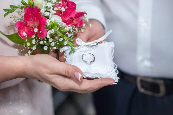 Mãos de homem e mulher com um buquê de flores segurando um pequeno pi — Fotografia de Stock