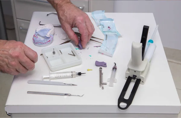 Mãos de dentista em uma mesa com instrumentos — Fotografia de Stock