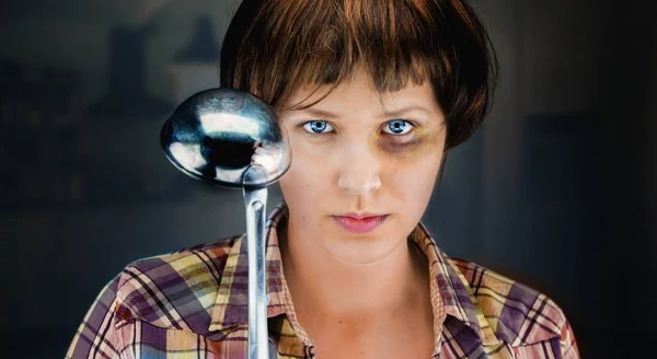 Woman with a bruise on her face and a ladle in her hand and an a — Stock Photo, Image