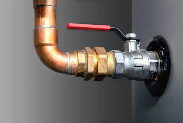 Copper pipes, copper connector and valve with a red handle — Stock Photo, Image