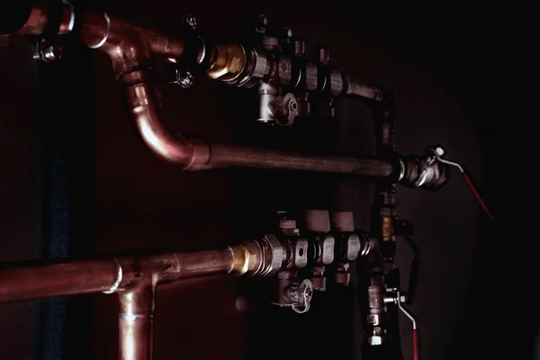 Tubos y válvulas de cobre en una oscuridad . — Foto de Stock