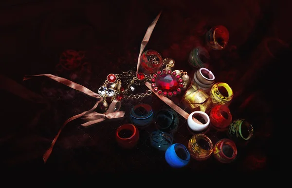 Wiele kolorowych szklanych pierścieni i neklace na ciemny czerwony tkaniny — Zdjęcie stockowe