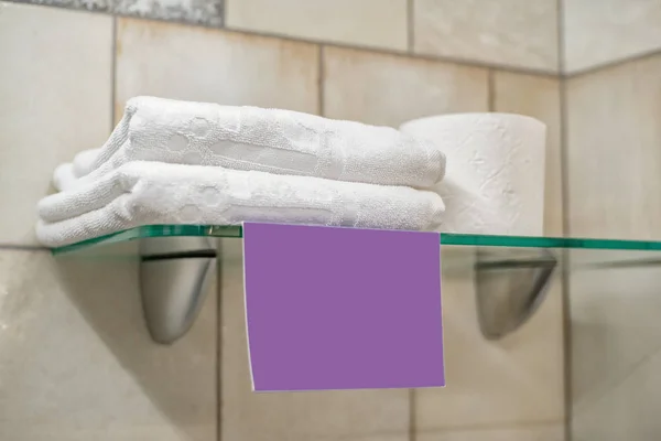 Two white towels, a roll of toilet paper and a blank lilac label — Stock Photo, Image