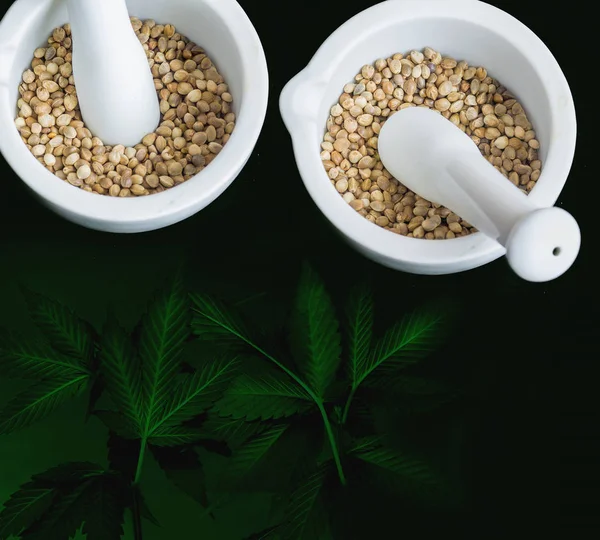 Close view of hemp seeds in  two white pestles — Stock Photo, Image