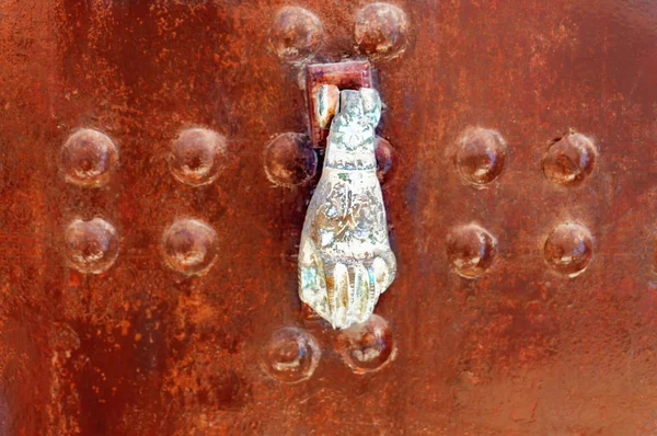 Door knocker hand on a painted door