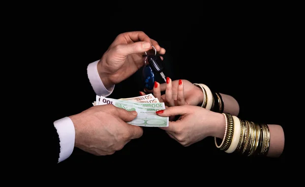 Mains d'homme donnant aux mains de femme billets en euros et clés de voiture — Photo