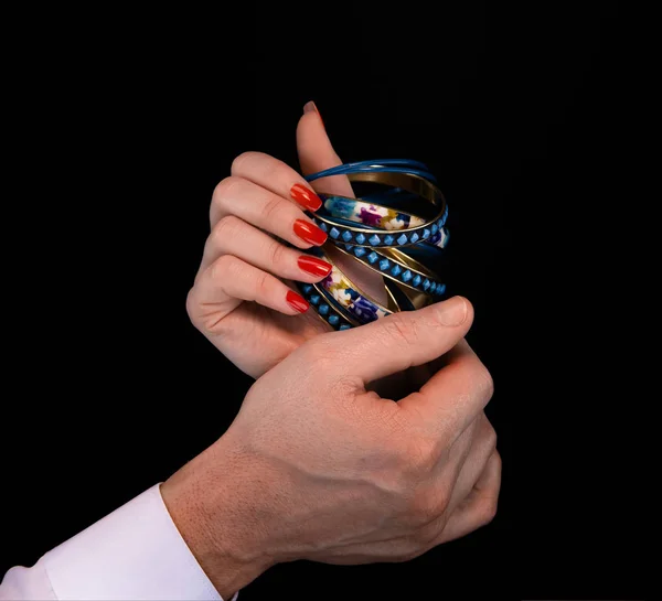 Mano degli uomini dando braccialetto blu alla mano della donna — Foto Stock