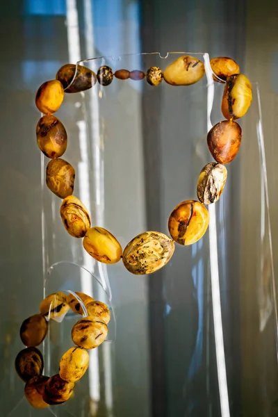 Amber halsband och armband på en glashylla. — Stockfoto