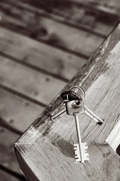 Különböző kulcsok gyűrűvel egy fa táblán — Stock Fotó