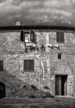 Pencereli, panjurlu ve ipli eski tuğladan bir ev
